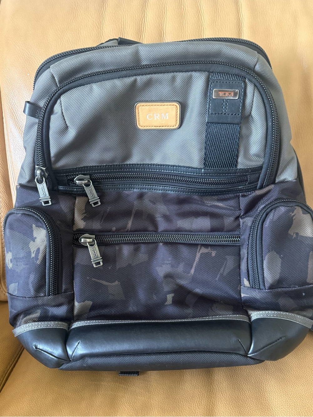 TUMI Men’s Black and Gray Travel Backpack, gray/ camouflage, orange interior .